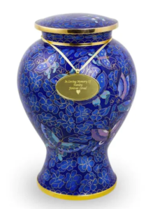 A beautifully designed blue cremation urn for human ashes with floral patterns and a gold nameplate.